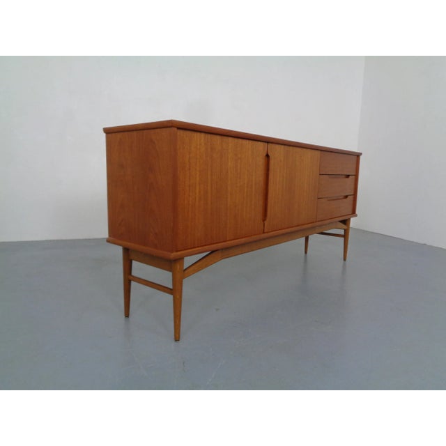 Teak sideboard, from the 1960s. Two doors with a shelf behind them. Three drawers on the left side.