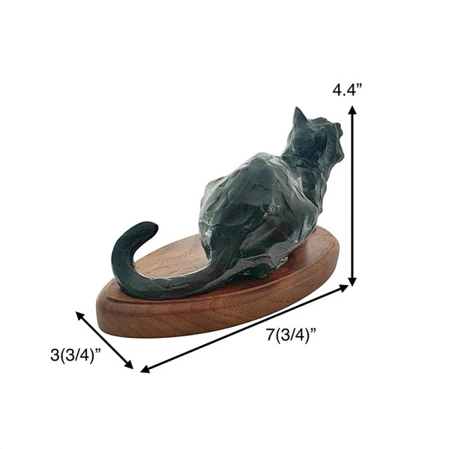 This exquisite bronze sculpture features a crouching cat poised on a solid wood base, masterfully capturing the grace and...