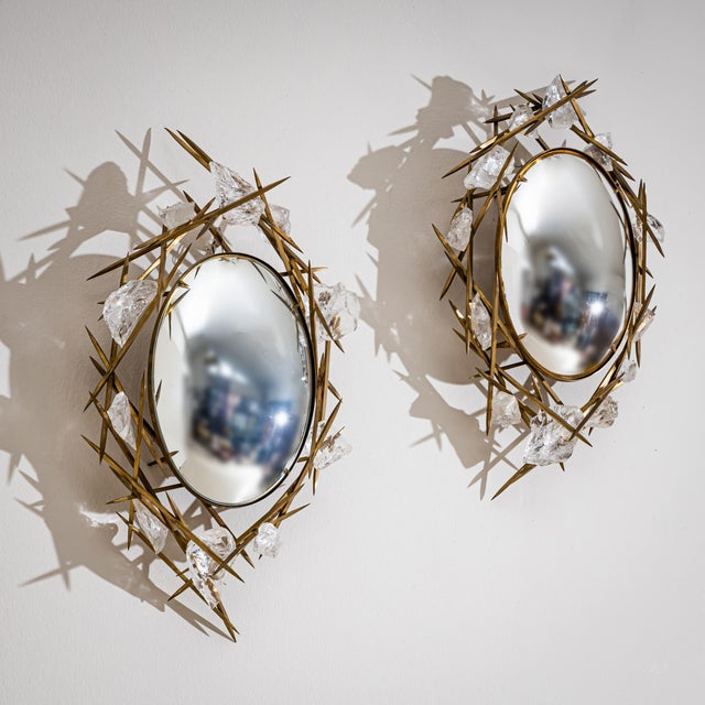 Pair of small oval wall mirrors with convex mirror glass and a brass frame of pointed thorns, surrounded by irregular...