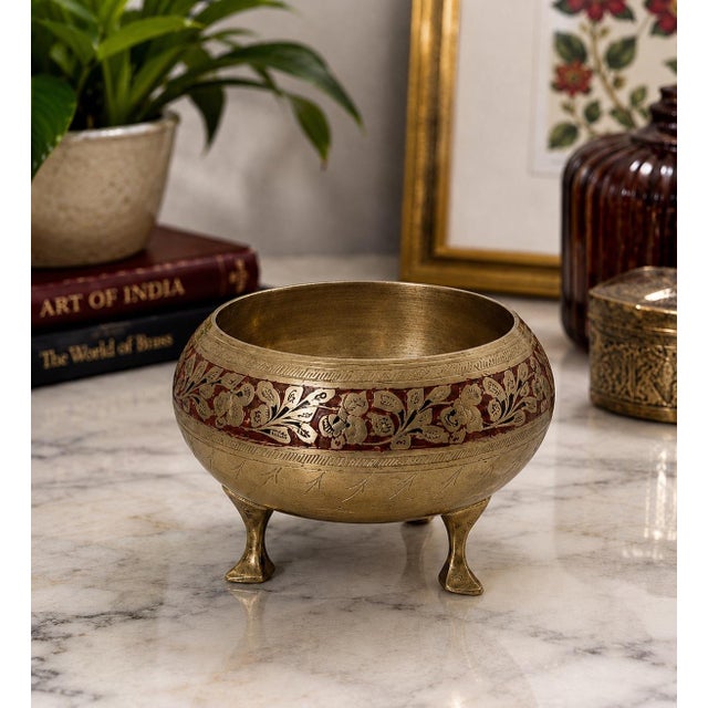 This charming vintage brass tripod bowl brings a touch of exotic sophistication to any space. Handcrafted in India and...