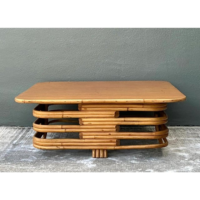 This vintage coffee table is a low, square-form design with softly rounded corners, built in the stacked rattan tradition...