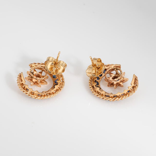 Stylish vintage sapphire crescent moon and star sapphire earrings crafted in 14 karat yellow gold (circa 1970s). Blue...