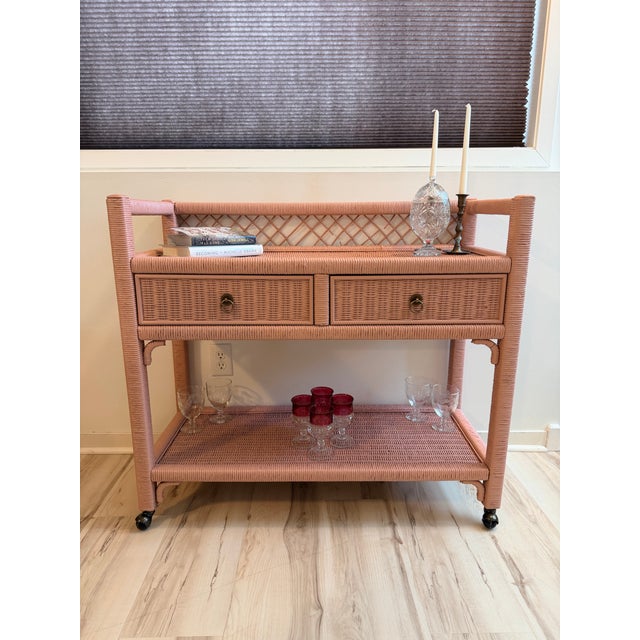 This is a lovely, vintage Henry Link wicker bar cart, serving cart, or console table in a dusty rose finish. Henry Link is...