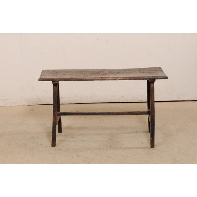 An Italian walnut wood coffee table from the 18th century. This antique table from Italy has a rectangular-shaped top,...