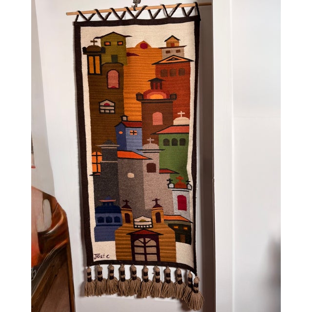 Handwoven architectural village scene by renowned Ecuadorian artist José Cotacachi, featuring a colorful geometric...