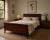 Elegant 1970s vintage queen-size bed frame by Drexel, crafted in mahogany and mahogany veneer with a rich reddish-brown...