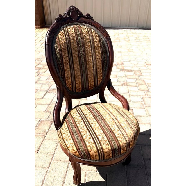 This chair exemplifies the ornate styling popular in the late 19th and early 20th centuries, drawing inspiration from...