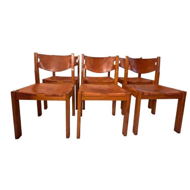 Set of 6 elm and leather chairs by Maison Regain. Handcrafted from solid wood with exceptional workmanship, under the...