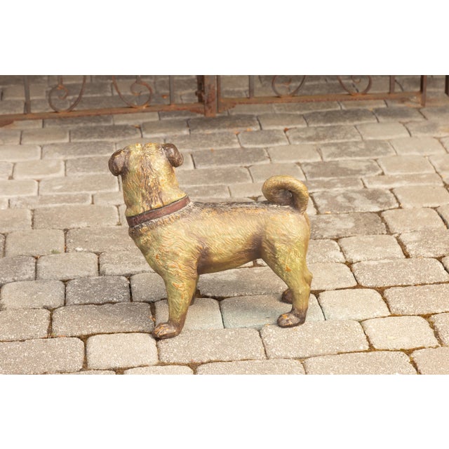 A vintage English composition standing dog sculpture from the 20th century, with glass eyes and red collar. Crafted in...