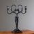 Candlestick crafted from iron, inspired by a Schinkel design, featuring a fur-clad herm resembling Dionysus and a square...