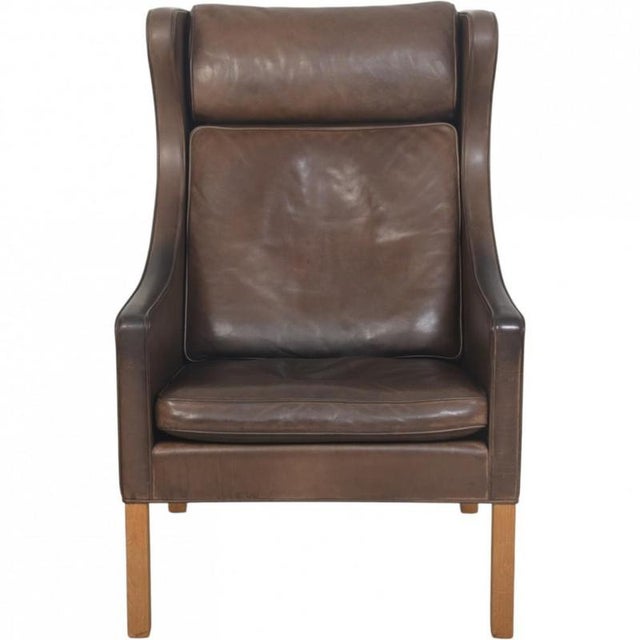 Børge Mogensen wing chair, model 2204, upholstered in original brown anilin leather with down cushions and legs of oak....