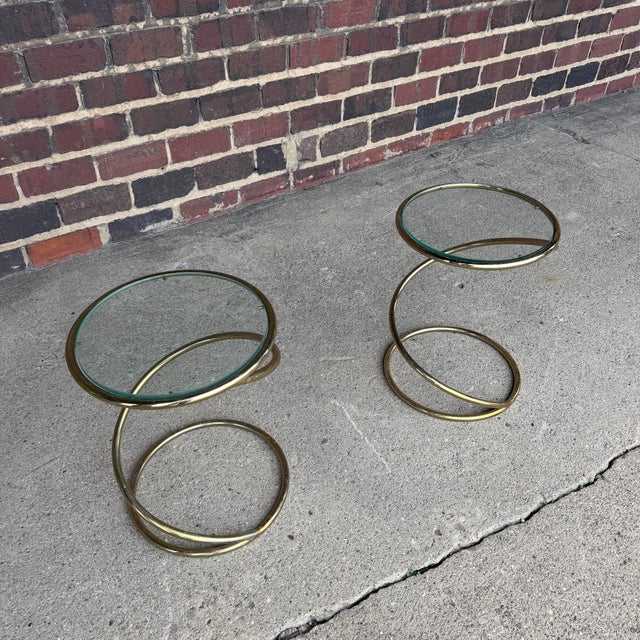 This is a pair of Leon Rosen for Pace brass and glass corkscrew side tables.