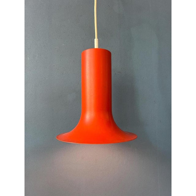 Orange mid century 'cone' pendant lamp by Raak. The shade is made out of metal and has an orange/red lacquer. The lamp...