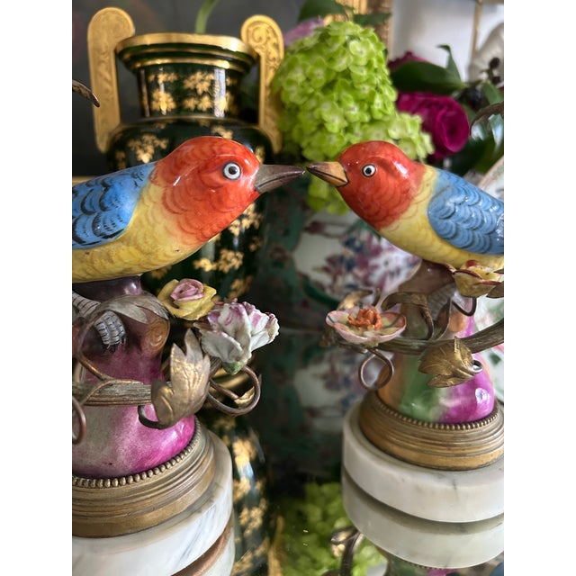 A delightful pair of French porcelain bird figural table lamps, dating to the early 20th century, each stamped Made in...