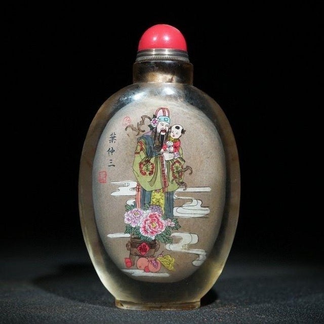 This is a charming vintage Chinese snuff bottle, crafted from Liuli (traditional Chinese glass) with a finely detailed...