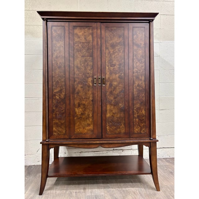 This is a gorgeous contemporary entertainment armoire / media cabinet in a warm dark cherry finish with striking burl-look...