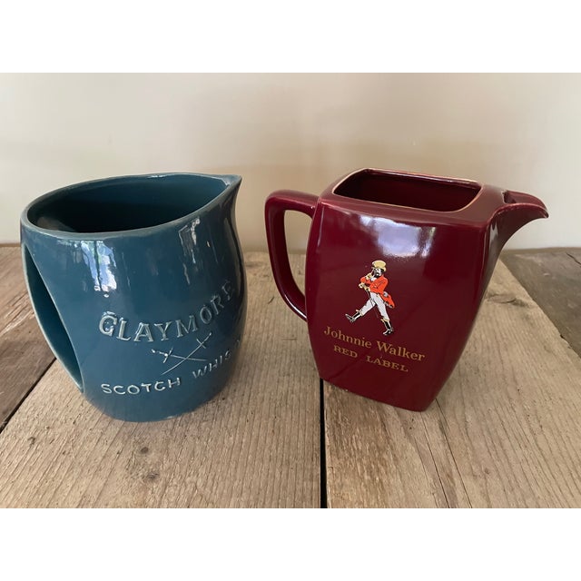 One advertising pitcher of Glaymore and the other of Johnnie Walker.