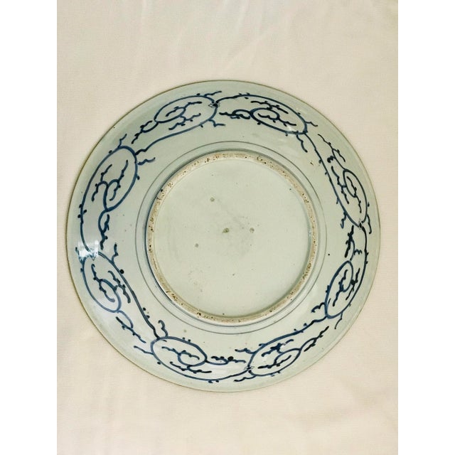 A fine and unusual porcelain charger. The center depicting two phoenix circling in intricate detail of underglaze blue....