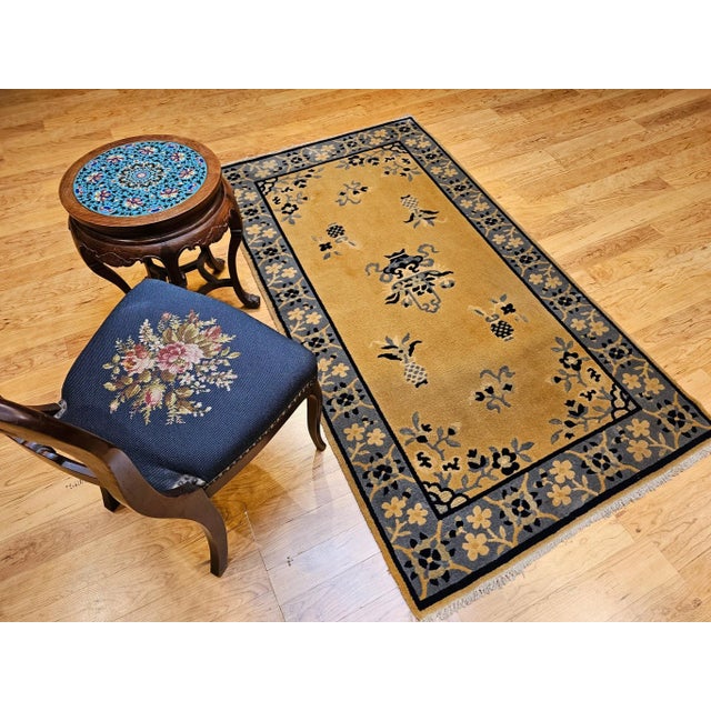 Graceful and timeless, this vintage Chinese Art Deco rug from the early 1900s showcases a serene tan wool field...