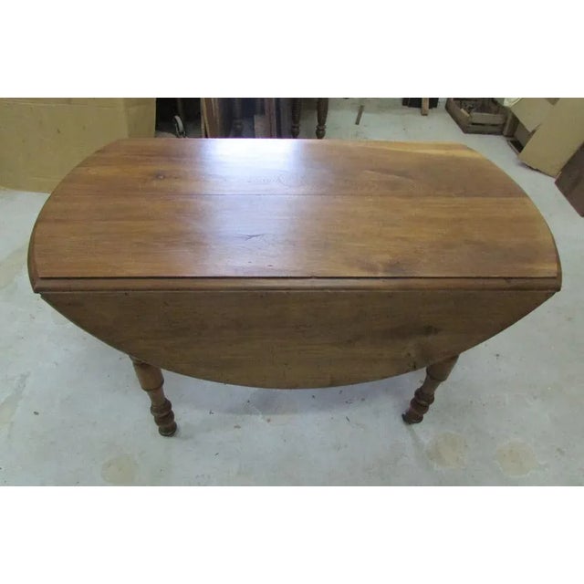 Dining table, almost round, with flaps, 4 feet balusters and casters. Bastily in quality oak, not opening but folding...