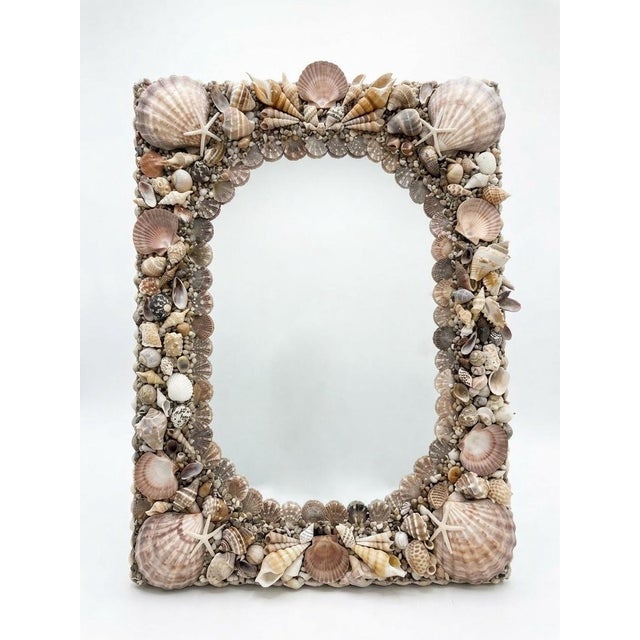 This vintage coastal wall mirror features an intricately encrusted frame that brings organic texture and nautical elegance...