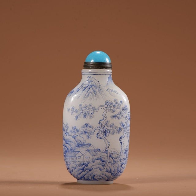 This is a finely crafted antique glass snuff bottle, featuring a painted enamel landscape scene on a white ground. The...
