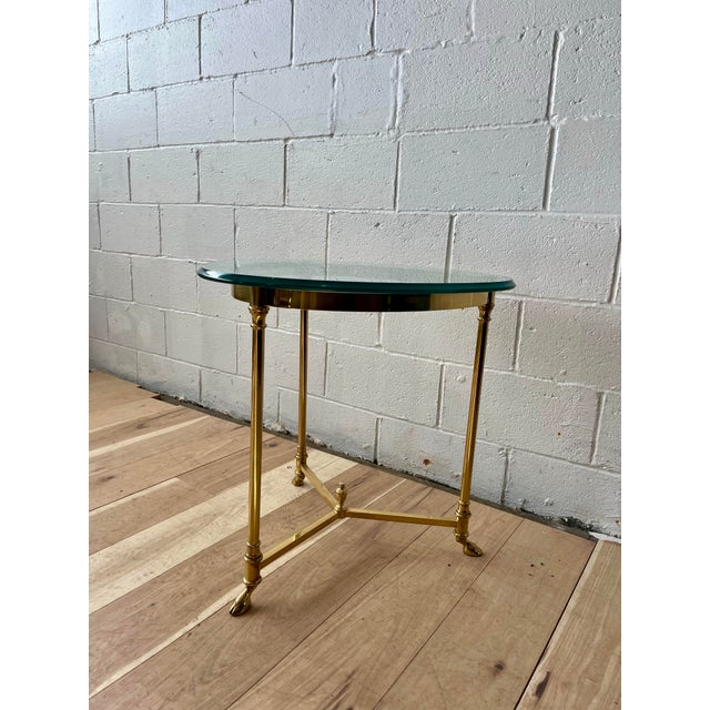 Elegant and timeless, this vintage Hollywood Regency side table features a refined brass frame topped with a thick round...