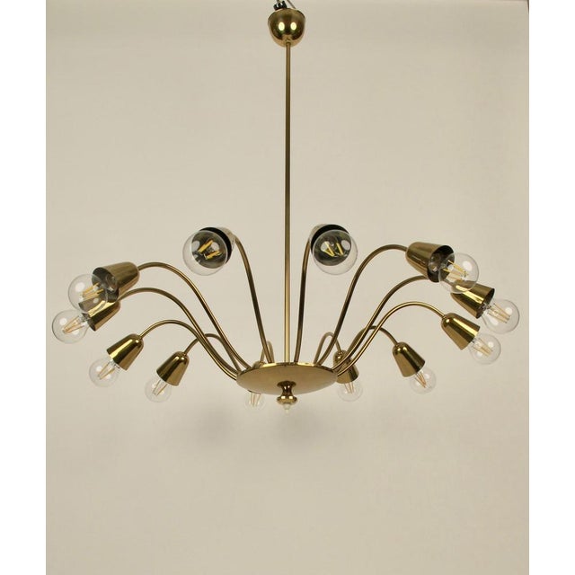 An elegant 12 arm, midcentury, chandilier in brass from Rupert Nikoll. Made in Austria this chandilier is typical for...