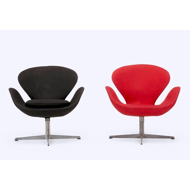 Authentic Arne Jacobsen Swan chairs model 3320, set of two red and black, manufactured by Fritz Hansen Denmark 1960s. The...