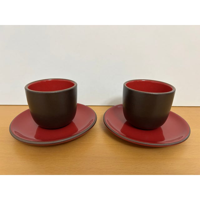 2 Sets of Heath Ceramics Small Cups and Saucers Glossy Red and Chocolate Brown glazes. Dimensions: Cups: 2-1/2" high,...