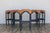 A striking set of five vintage bar stools featuring rich, distressed leather seats paired with beautifully turned solid...