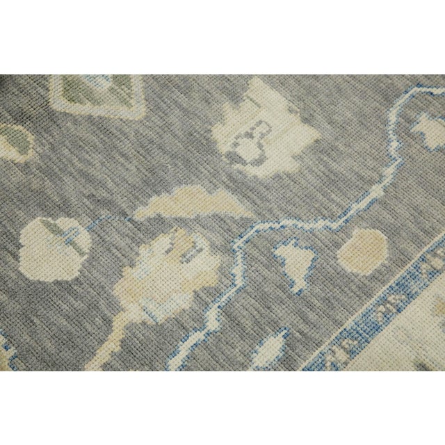 This modern Turkish Oushak rug is a stunning piece of art that has been handwoven using traditional techniques by skilled...