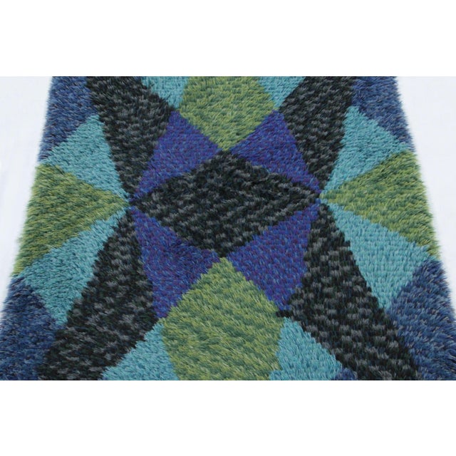 Hand-knotted in lush, high-pile wool in Sweden circa 1960-1970, this 3x5 vintage Swedish Rya rug is a bold new addition to...