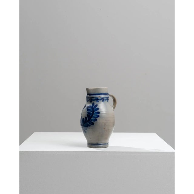 This exquisite 1900s Belgian ceramic jug captures the essence of traditional European craftsmanship. The jug features a...
