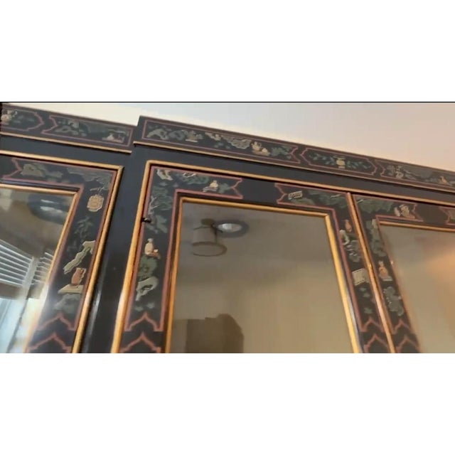 Beautiful black and gold display cabinet with glass doors and Asian-inspired design. Has four doors with gold handles and...