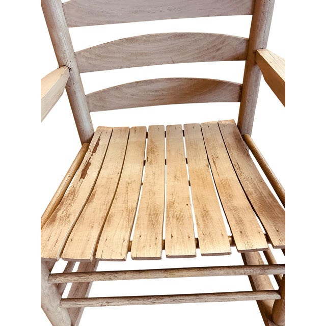 Handcrafted hickory rocking chair featuring a traditional ladder-back silhouette, bark-on posts, steam-bent slats, and a...