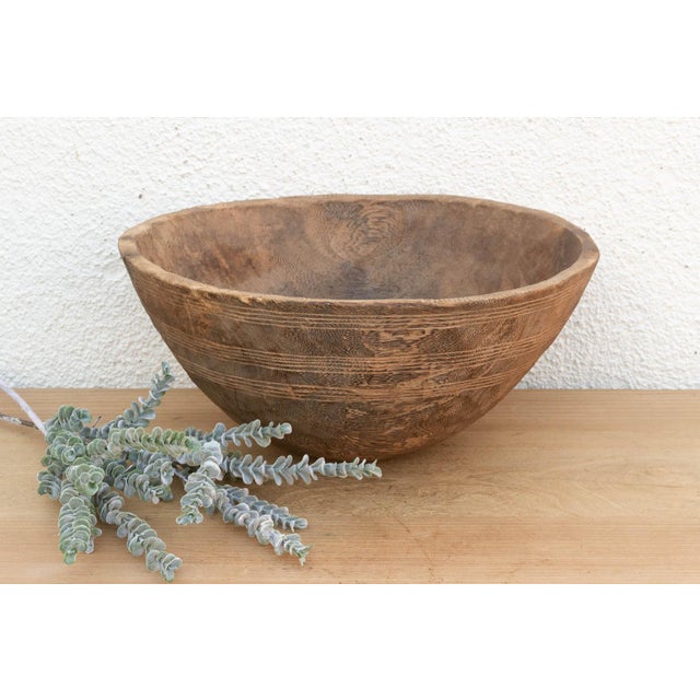 There is something deeply grounding about holding a vessel that was hewn by hand from a single block of wood. This antique...