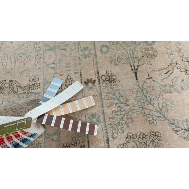 An early 20th century handmade wool Persian Kirman (Kerman) antique rug. The beige field is covered with a delicately-...