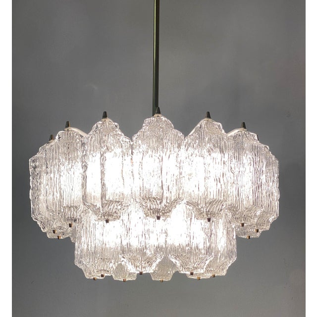 Brass frame partially white painted fitted with 12 E14 sockets and 22 ice glass elements. Made in the 1960s by Stölzle in...