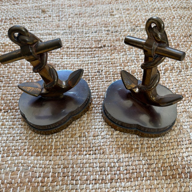 This is a handsome pair of vintage brass nautical anchor bookends, each featuring a dimensional ship’s anchor entwined...