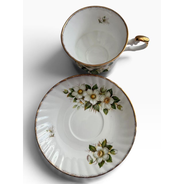 Elegant vintage Royal Minster Christmas Rose teacup and saucer in fine bone china, featuring a beautifully detailed...