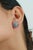These floral halo stud earrings feature 6.32 carats of cabochon turquoise and pink sapphires set in 14K yellow gold and....