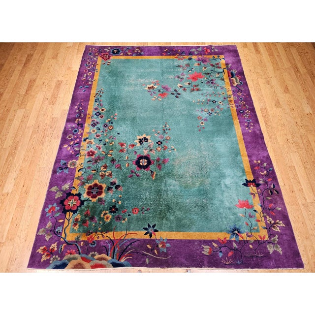 A vibrant expression of early 20th-century Chinese Art Deco design, this hand-knotted rug features a serene green field...