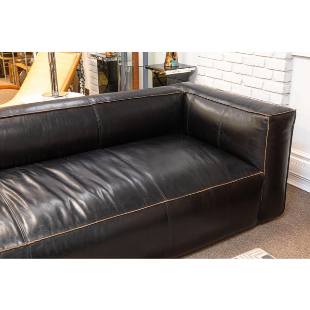 A Four Hands "Nolita" black leather sofa. This is a gorgeous black leather sofa featuring a chic reverse stitching design....