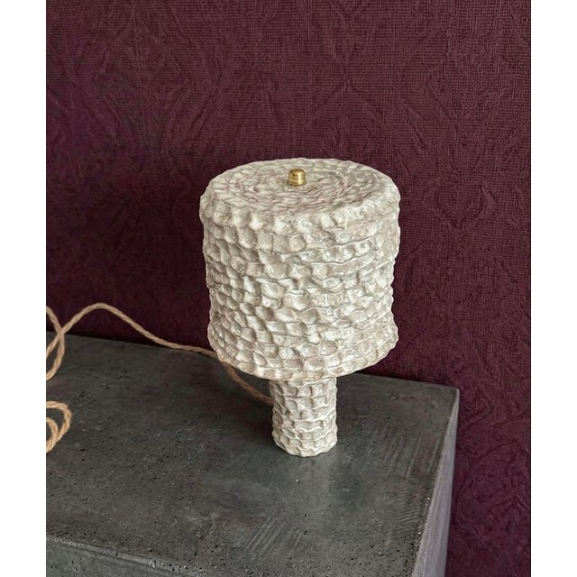 Handmade ceramic table lamp with a textured stoneware surface and neutral glaze. The lamp features a sculptural ceramic...