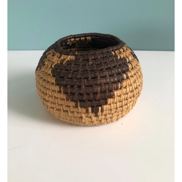 Small tan and brown Southwest Style round woven decorative basket. Size: 5.5"D x 3.5"H.