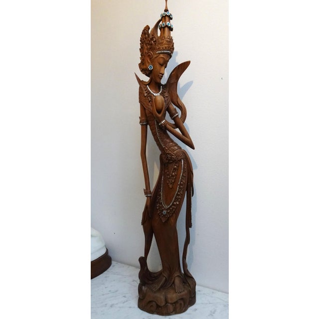 The glass fantasie beads on it are not original. Statue has been decorated with jewelry later. Can be taken off is you wish