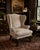 A handsome Ralph Lauren Home Devonshire wingback chair, upholstered in luxurious neutral suede and detailed with classic...