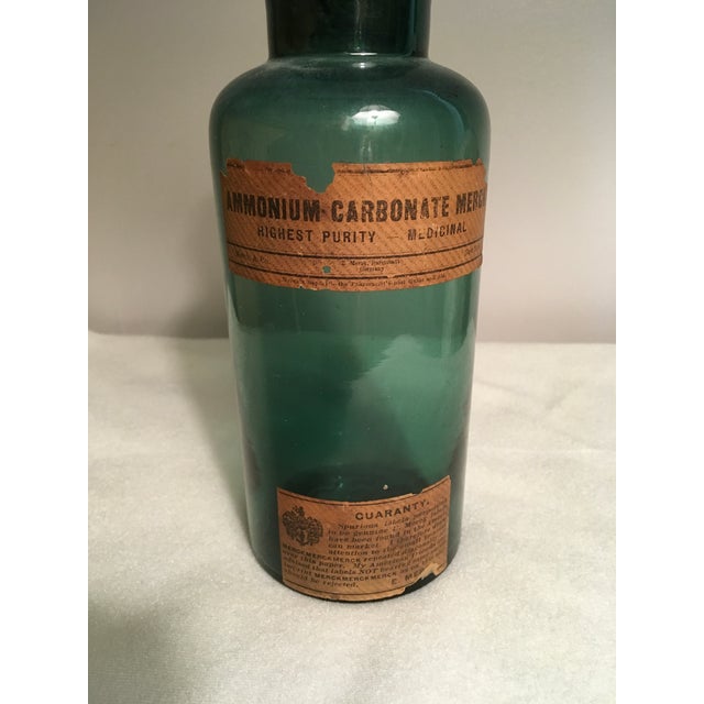 Wonderful early 1900s Apothecary Jar. It is dark bottle green, 7” high, and still has the original MERCK labels and...