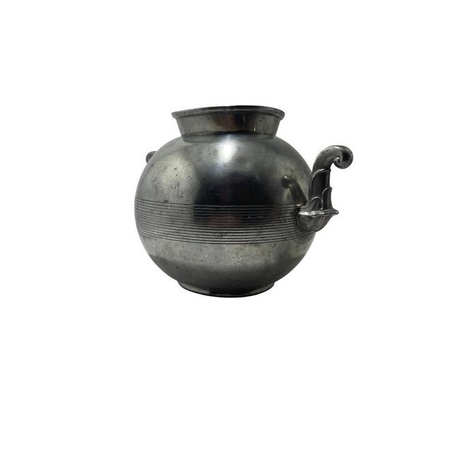 A striking art deco pewter vase by guldsmedsaktiebolaget (gab), sweden, dated 1939. This sculptural piece features a bold,...